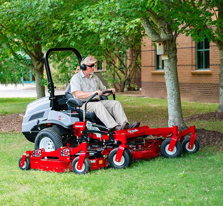 man outside driving a commercial grade mower